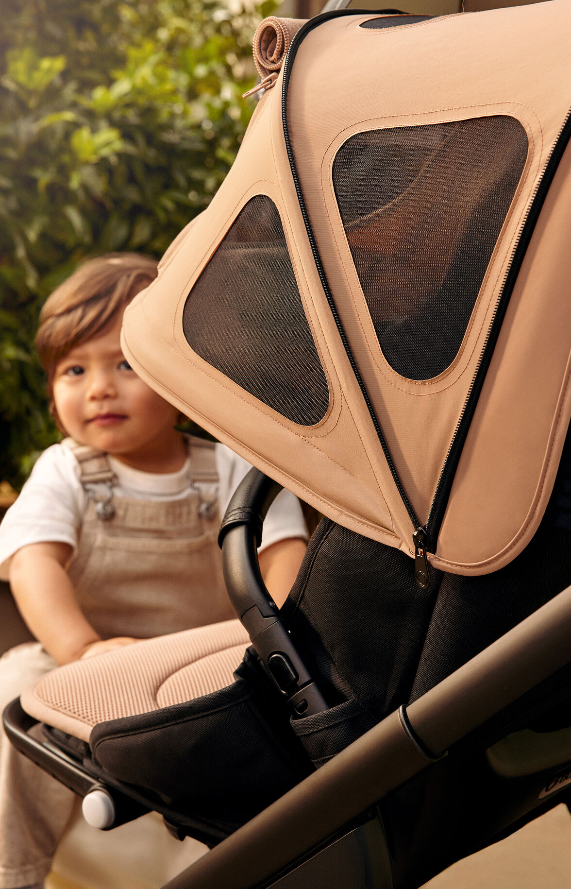 Baby getting into Bugaboo stroller with breezy sun canopy on it