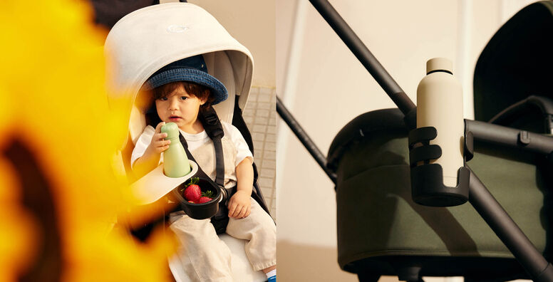 A collage of two images. On the left, a baby wearing a denim hat and beige overalls sits in a Bugaboo stroller, in front of him is a snack tray with a water bottle and a compartment full of strawberries. On the right, a close-up of a water bottle secured in a cup holder attached to a Bugaboo stroller handlebar.