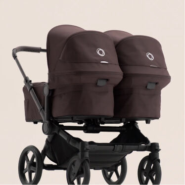 두 개의 배시넷이 나란히 배치된 부가부 동키 6 스트롤러를 보여주는 움직이는 GIF 영상. 배시넷 안에는 두 명의 아기가 웃고 있습니다.