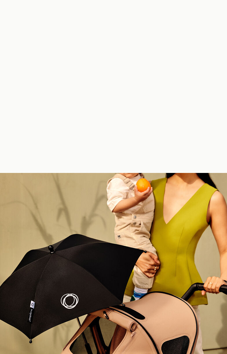 Mom pushing Bugaboo stroller with breezy sun canopy and parasol attached