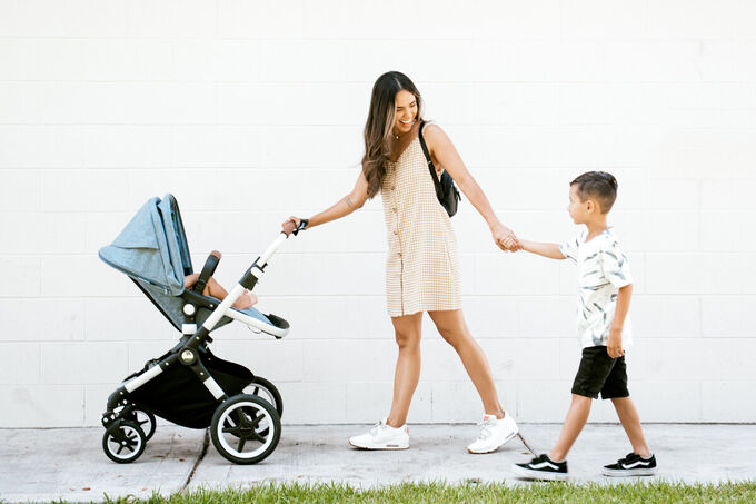 Mom holding brothers hand and pushing stroller