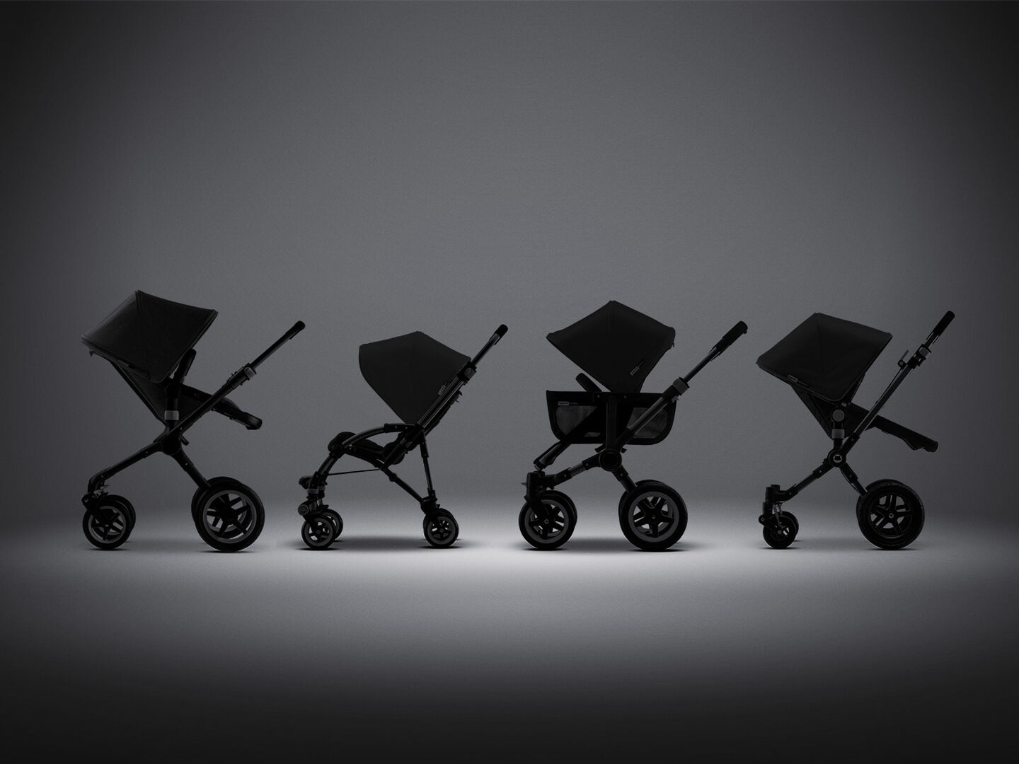 Four backlit Bugaboo strollers on display.
