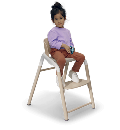 Kind in einem Bugaboo Giraffe Stuhl.