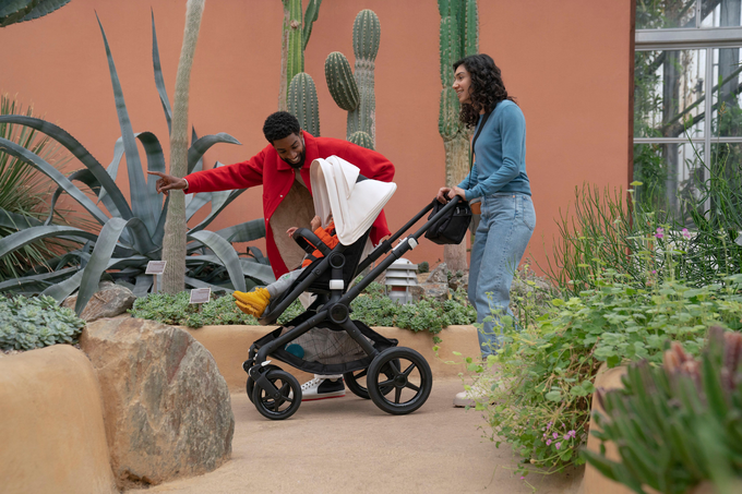 Parents pushing their baby in a pushchair 