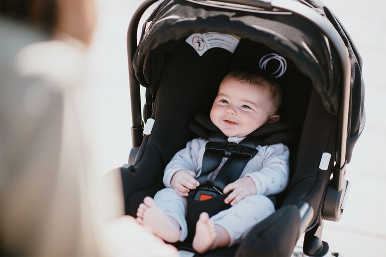 Baby riding in car seat on plane