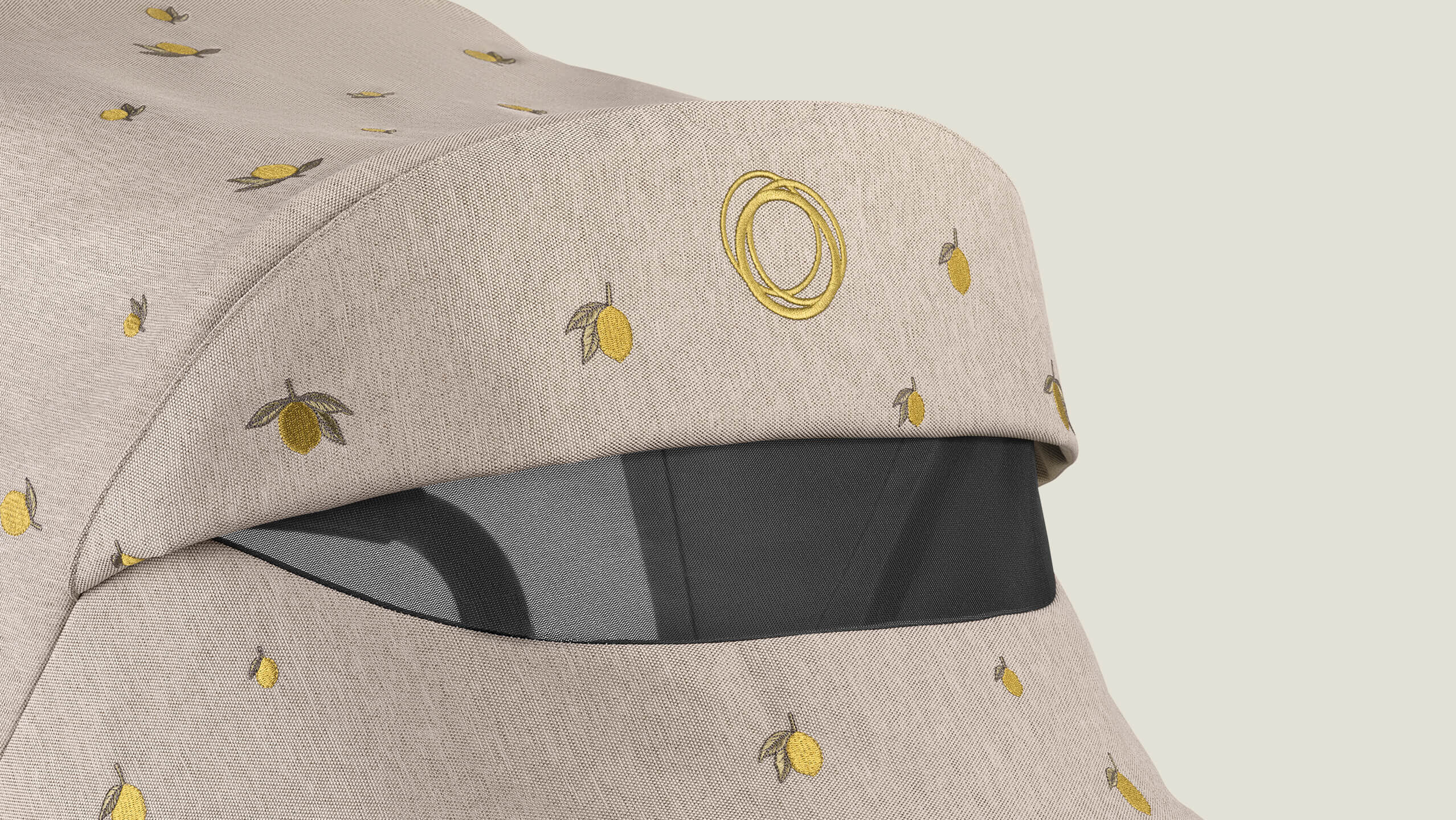 A close-up of Bugaboo X Konges Sløjd Limited Edition sun canopy with peek-a-boo window, showcasing the Bugaboo logo and Konges Sløjd's signature lemon print.