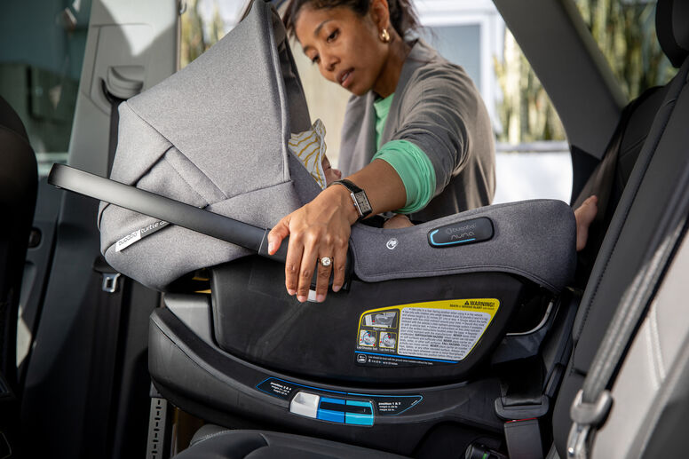 Mom putting car seat in car
