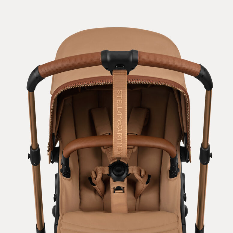 Vue de face d'une poussette Bugaboo x Stella McCartney Dragonfly Plus avec siège, revêtue de tissus de couleur Tobacco Brown et agrémentée de poignées Saddle Brown.