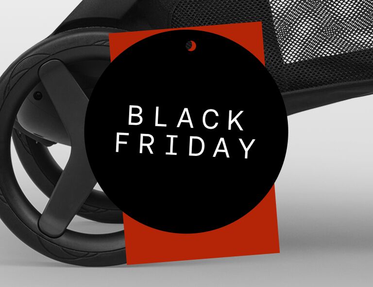 Close-up of a Bugaboo stroller wheel, below a red price-tag shape. On top is a black circular badge with the words “Black Friday” in white.