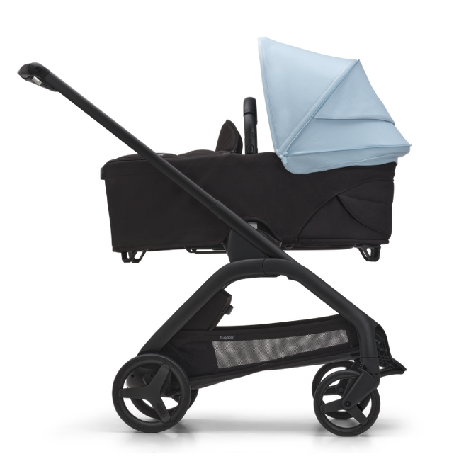 Sideway view of a Bugaboo Dragonfly compact stroller with a bassinet and a Skyline Blue canopy.