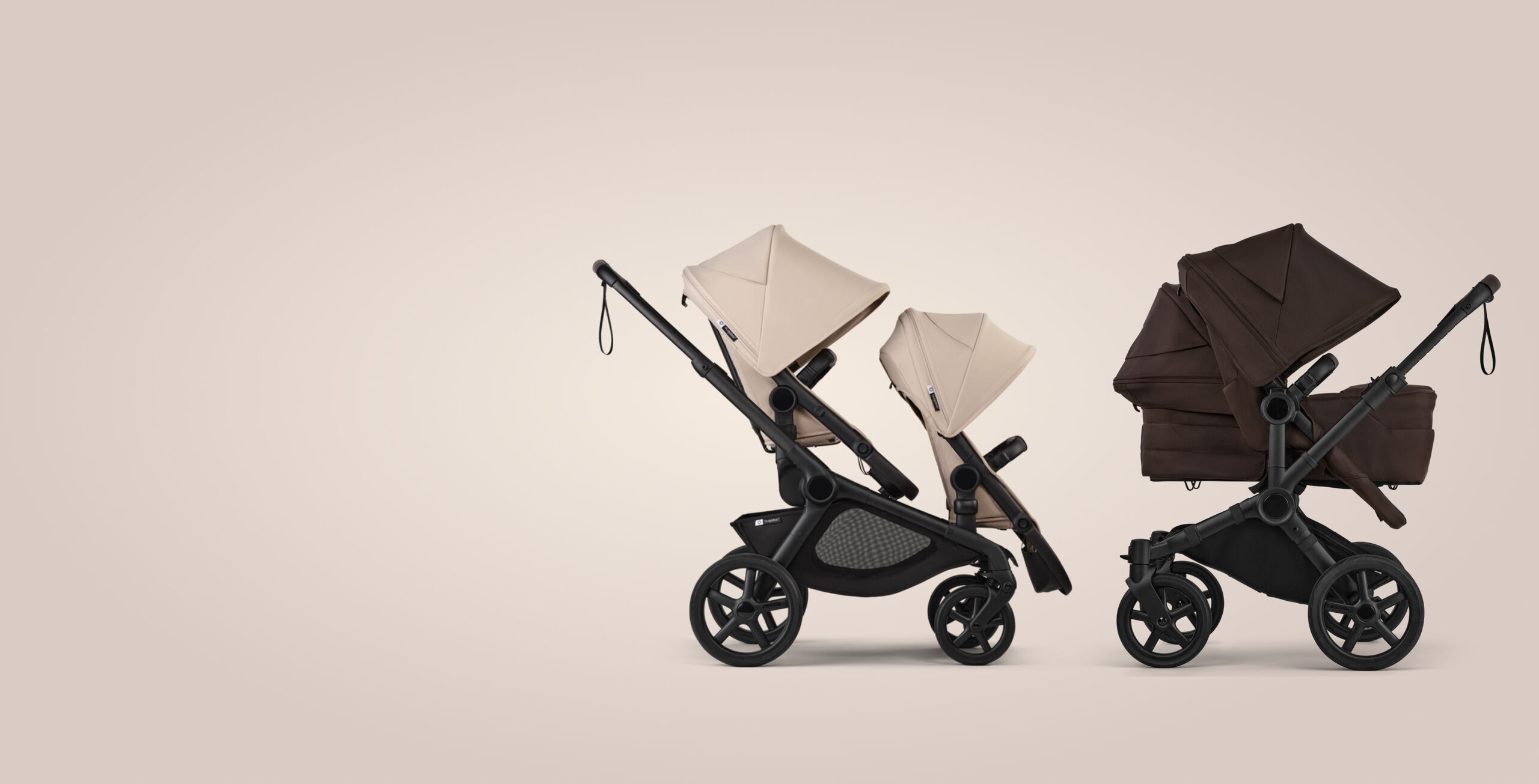 Two Bugaboo strollers in a row. On the left, a Bugaboo Kangaroo tandem stroller with two seats, in Desert Taupe fabrics. On the right, a Bugaboo Donkey 6 double stroller with a seat and a bassinet, in Cocoa Brown fabrics.