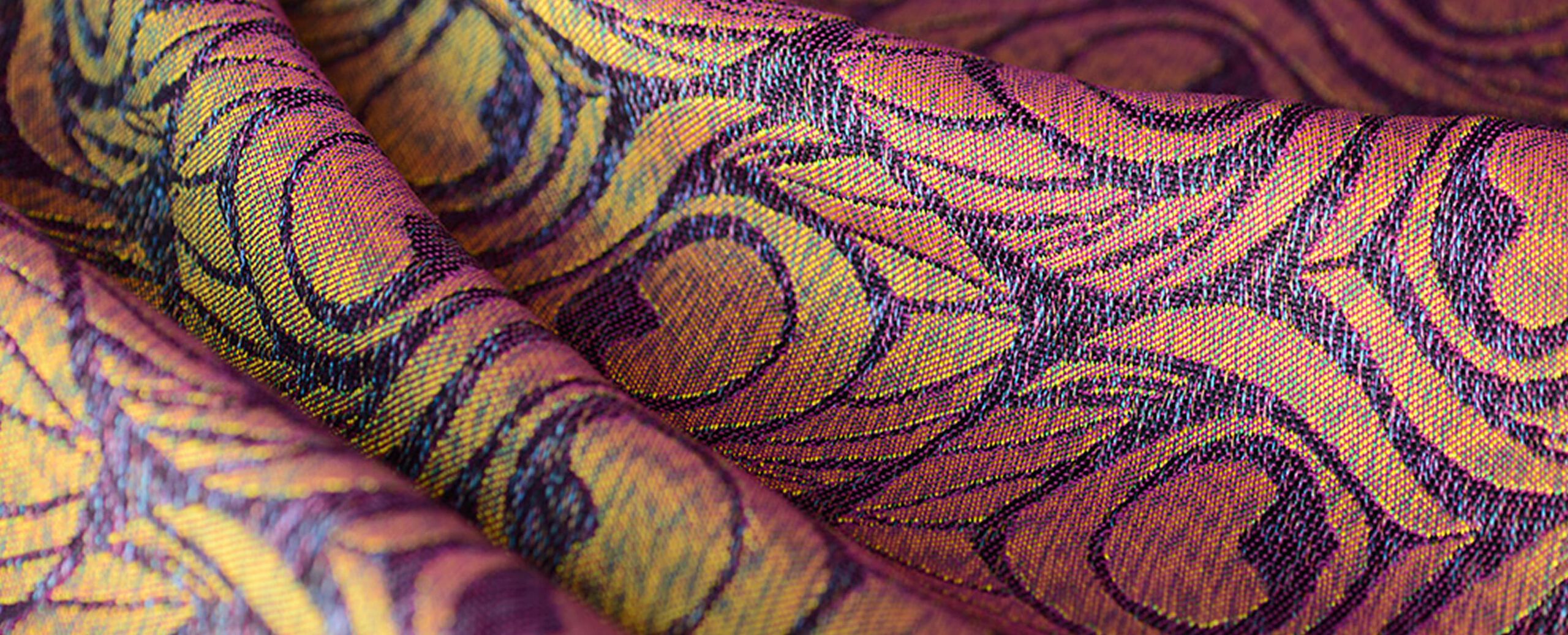 Close up on the jacquard-woven iridescent fabric of the Bugaboo X Artipoppe Limited Edition. The fabric shines a golden-purple hue in the light.