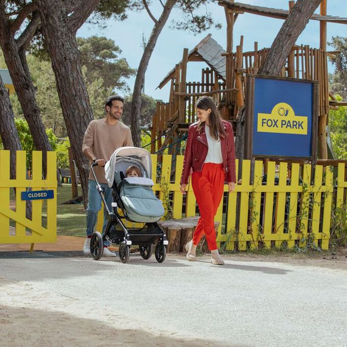 Una pareja paseando en un parque con su bebé sentado en el carrito todoterreno Bugaboo Fox 3.