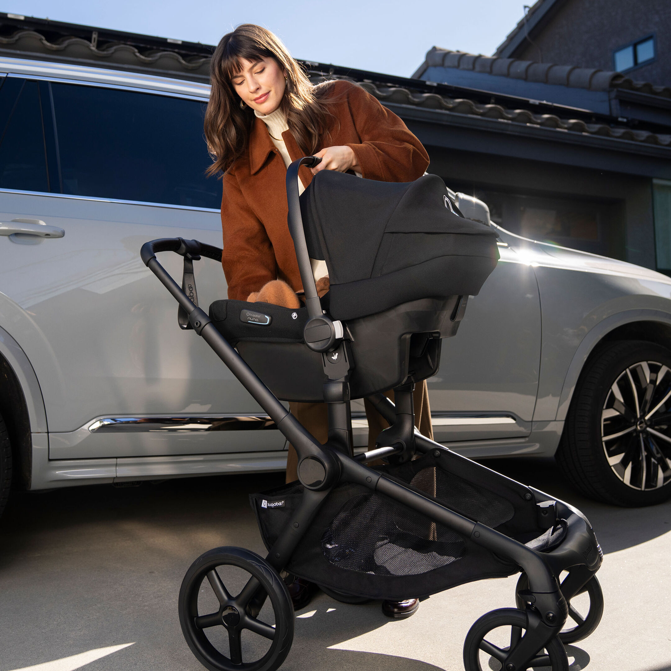 Mom putting Bugaboo Turtle Air Shield by Nuna on Bugaboo Kangaroo