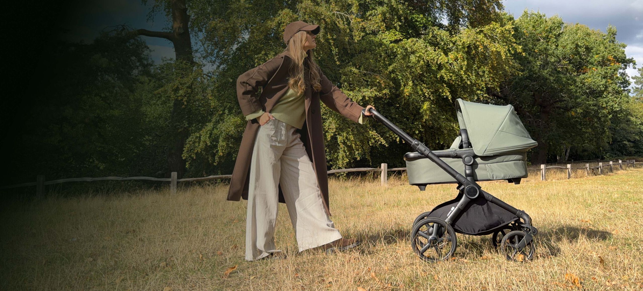 A Bugaboo Cub all-terrain pushchair in black fabrics inside a studio space, next to piles of sand on the ground.