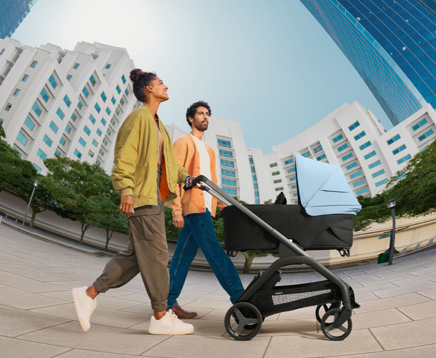 Parents taking a Bugaboo Dragonfly city pushchair out on a stroll.	 	 	