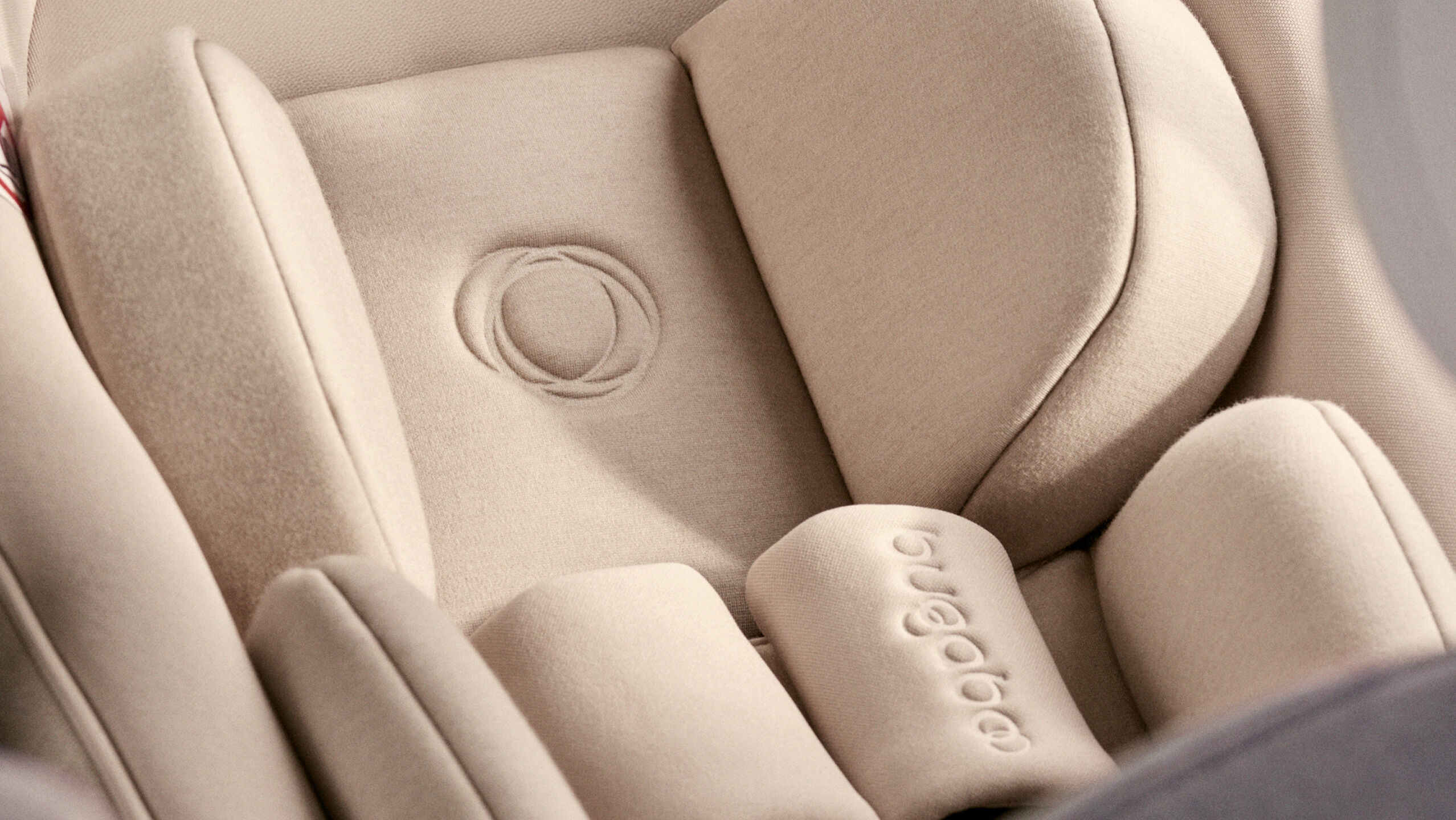 Gros plan sur les tissus doux de qualité supérieure du siège auto Bugaboo Otter by Nuna. Le logo Bugaboo est embossé sur l'insert pour bébé.