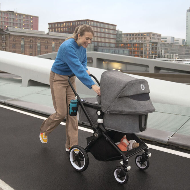 Mom jogging with the Lynx stroller with bassinet.