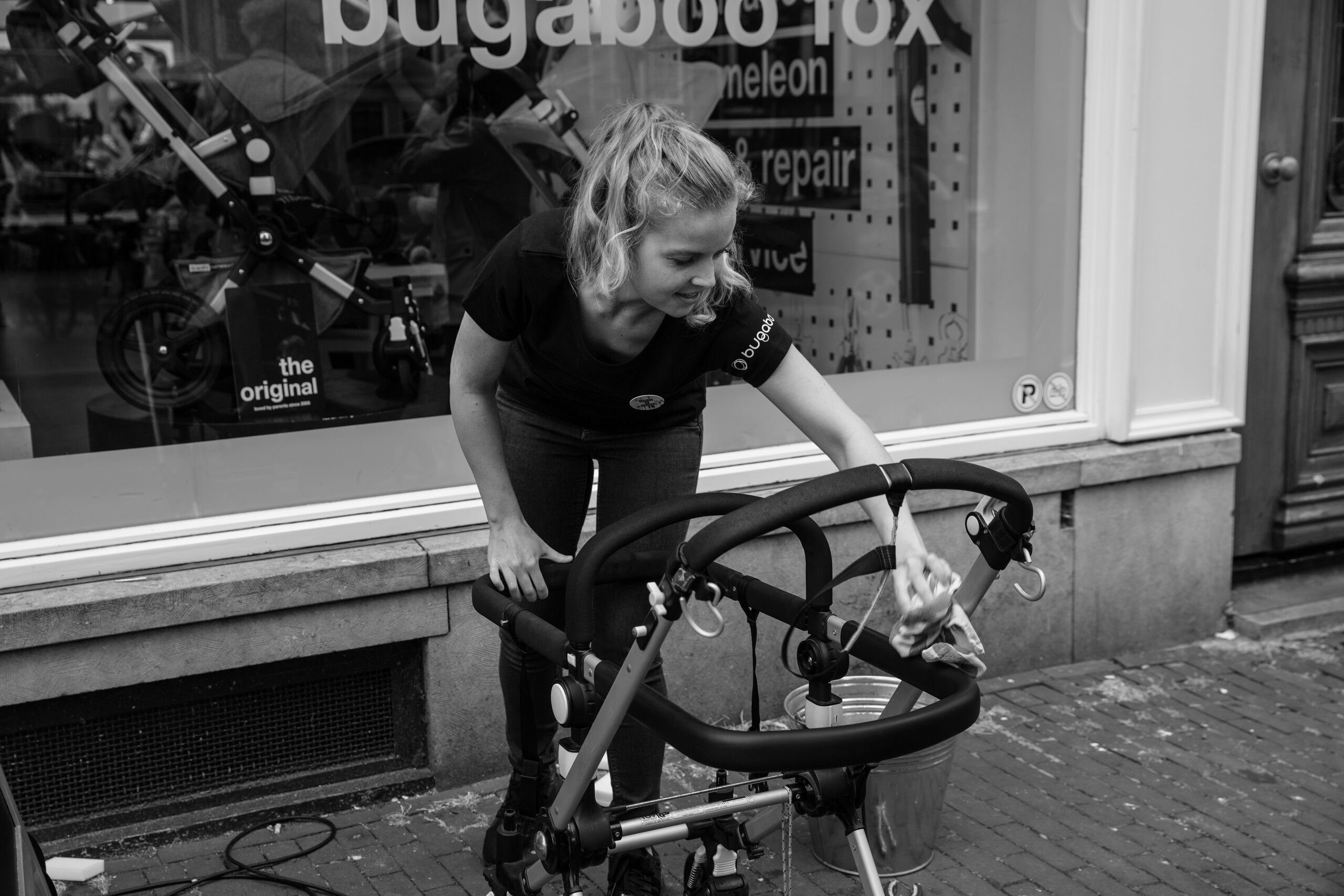 Eine Person reinigt das Gestell des Bugaboo Kinderwagens