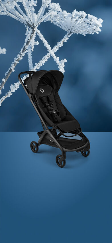 A Bugaboo Butterfly 2 travel stroller displayed against a blue background, with frosted winter plants on above of the image.
