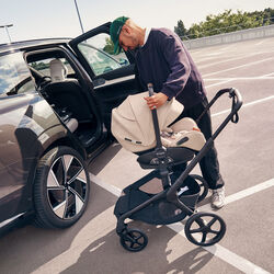 A parent lifts the Bugaboo Otter by Nuna infant car seat from a Bugaboo stroller to move their baby to the car.