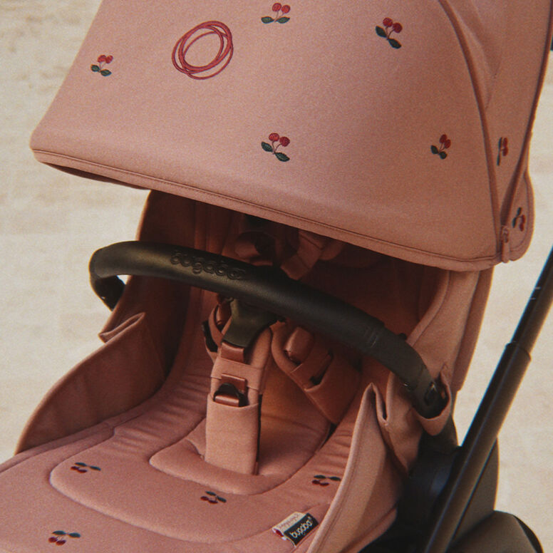 Ein Vater und seine Tochter hocken in einem wilden, überwucherten Garten. Er zeigt ihr etwas, das er in seinen Händen gefangen hat.