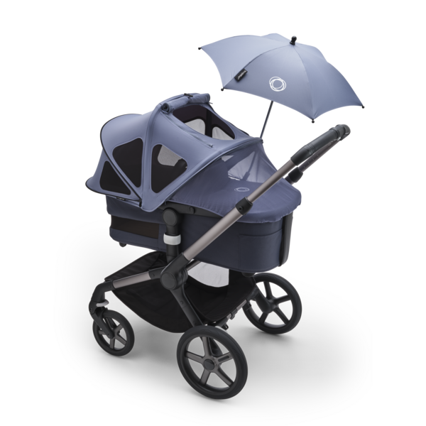 A Bugaboo pram with Bugaboo parasol and Bugaboo breezy sun canopy fully extended to cover the bassinet.