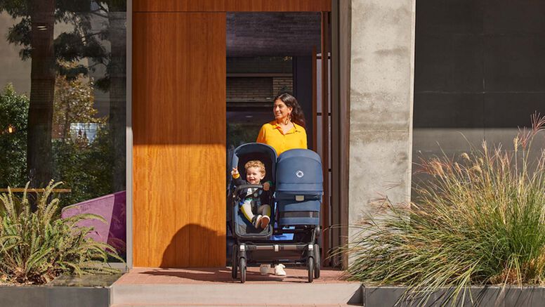 Mom pushing side-by-side double stroller outside