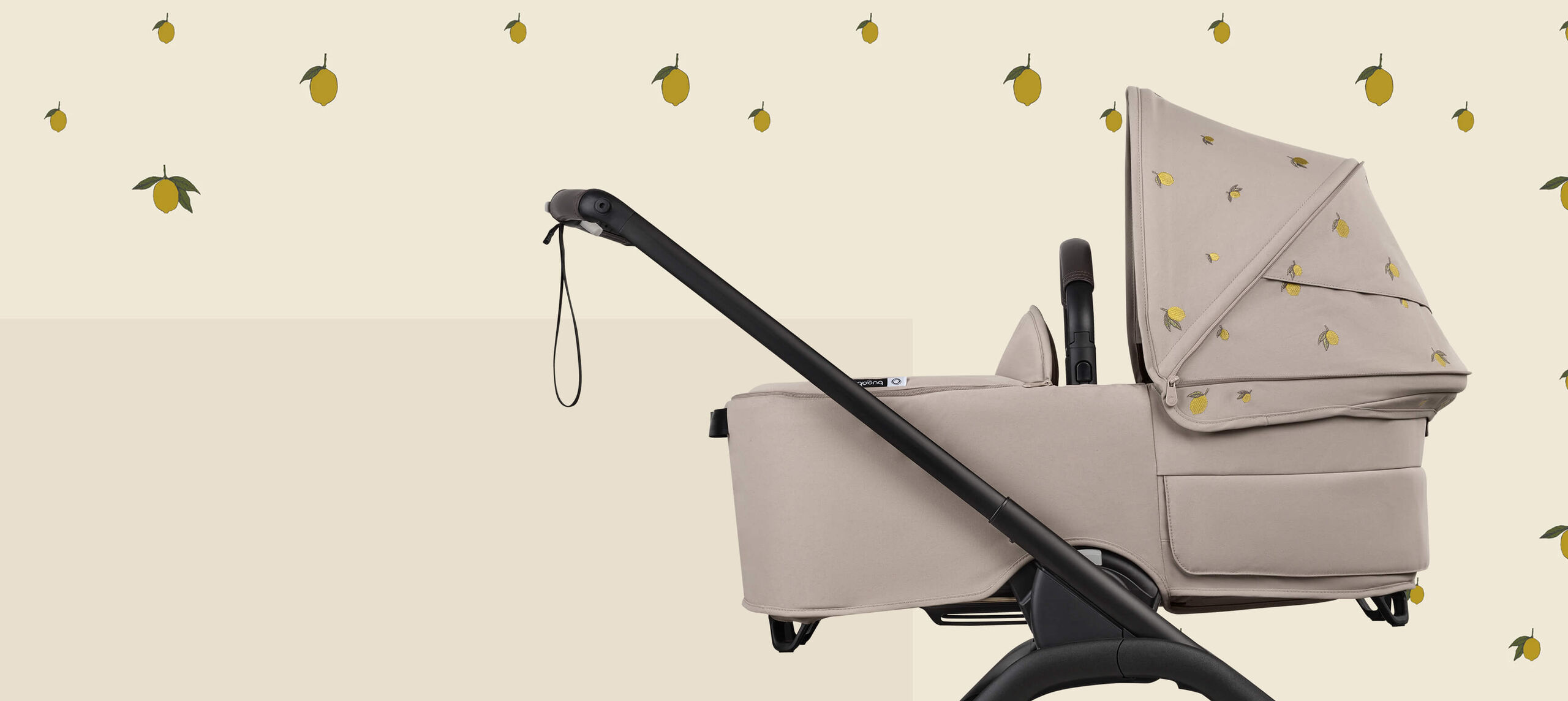 A Bugaboo Dragonfly bassinet stroller with Bugaboo X Konges Sløjd Limited Edition sun canopy, featuring Konges Sløjd's signature lemon print.