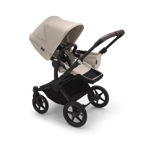 A Bugaboo Fox 5 all-terrain stroller with a bassinet. The fabrics are in Forest Green. The background is reddish with streaks of gold.