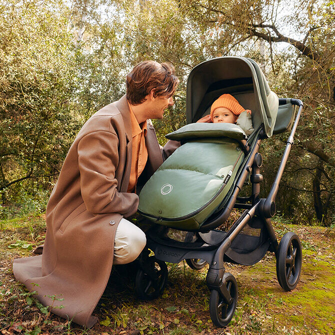 A Bugaboo stroller with the Bugaboo footmuff and Bugaboo changing bag.