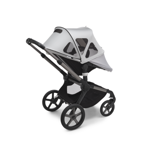 A Bugaboo stroller with Bugaboo white breezy sun canopy fully extended to cover the seat.