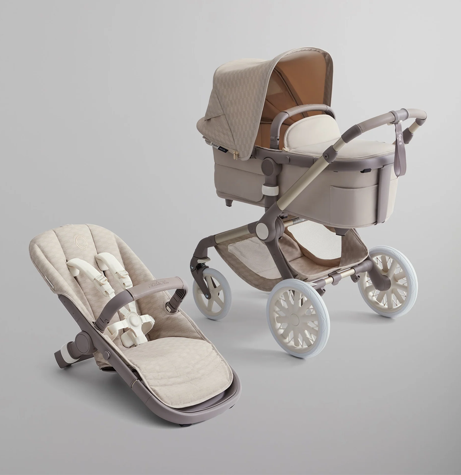 A Bugaboo Fox stroller with a bassinet and seat decked out in white/beige fabrics within the Kith for Bugaboo limited collection.