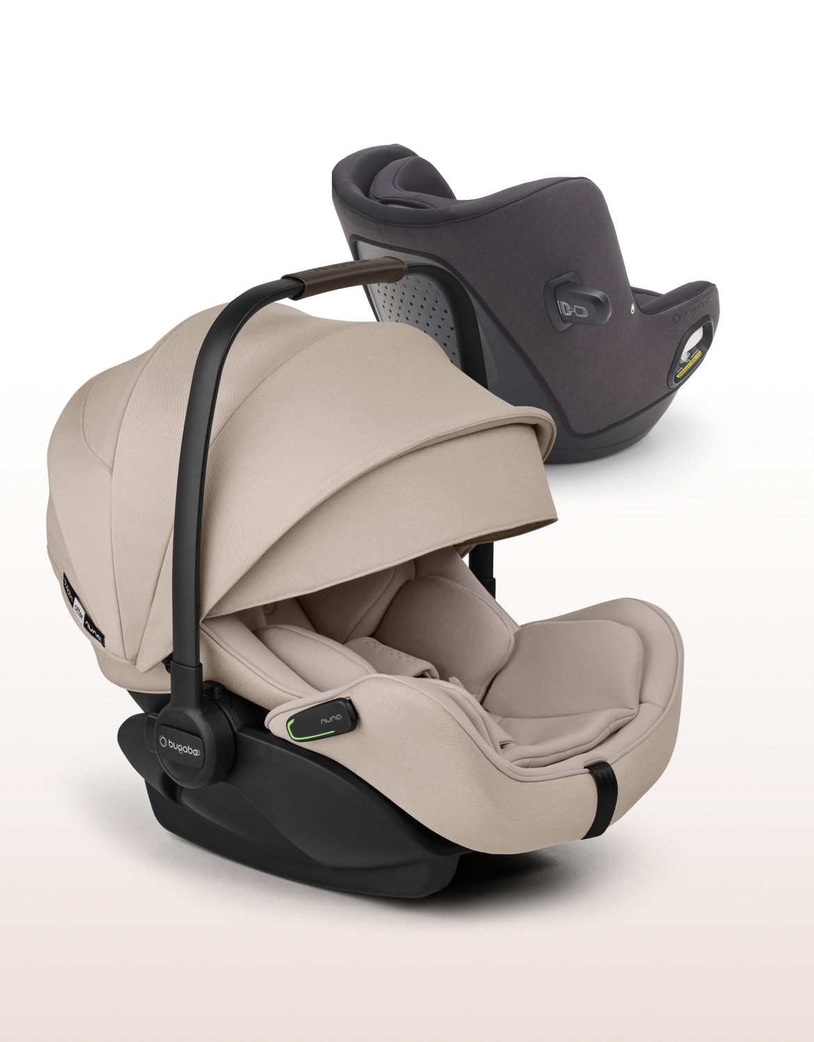Image de deux sièges auto Au premier plan, le siège auto pour bébé Bugaboo Otter by Nuna avec des tissus Desert Taupe. À l'arrière, se trouve le siège auto convertible Bugaboo Owl by Nuna avec des tissus noirs.