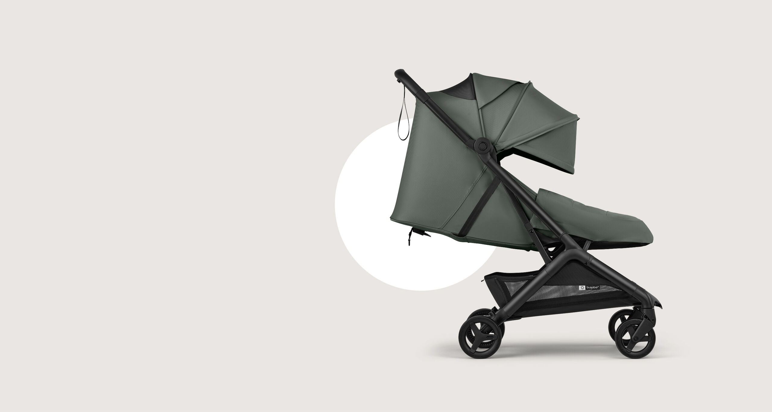 The Bugaboo Butterfly 2 Plus travel stroller in green fabrics, showing the lay-flat seat and the built-in newborn foot cover.