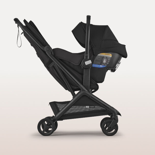 Side view of a Bugaboo Turtle by Nuna car seat attached on a Bugaboo pram with a seat.