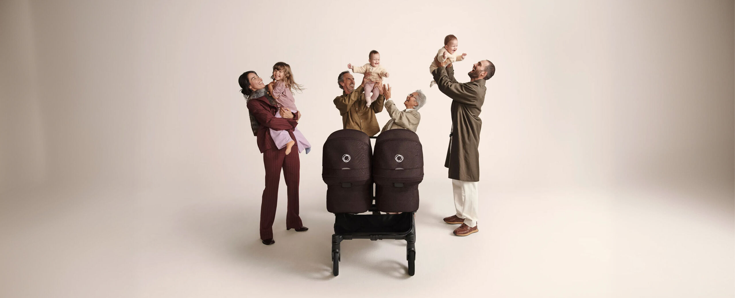 A toddler relaxes in the seat of an ultra-compact Bugaboo Butterfly travel stroller. The toddler is securely seated with the harness fastened and a Bugaboo Butterfly bumper bar across their middle.