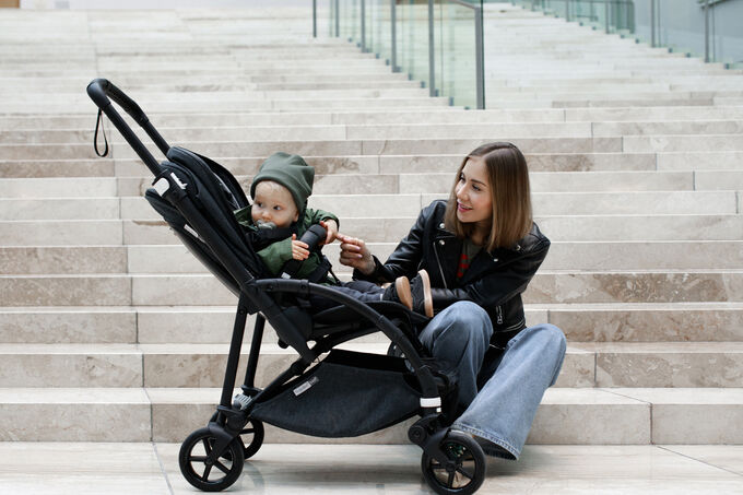 Mom sitting on stairs with baby in stroller