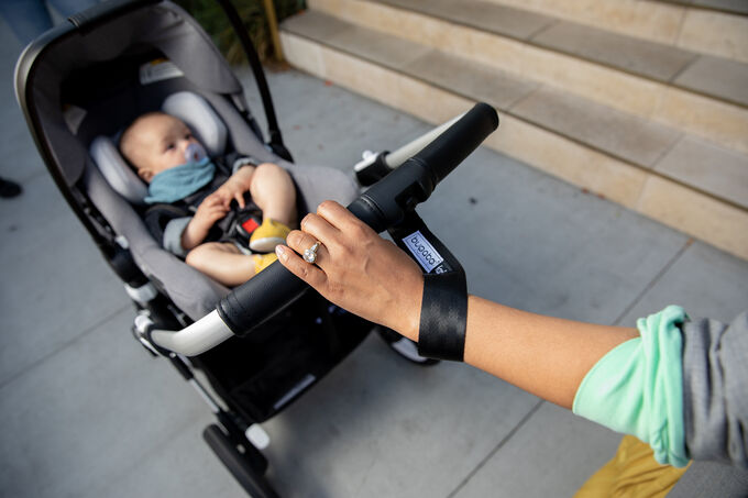 Mom pushing stroller with wrist strap on