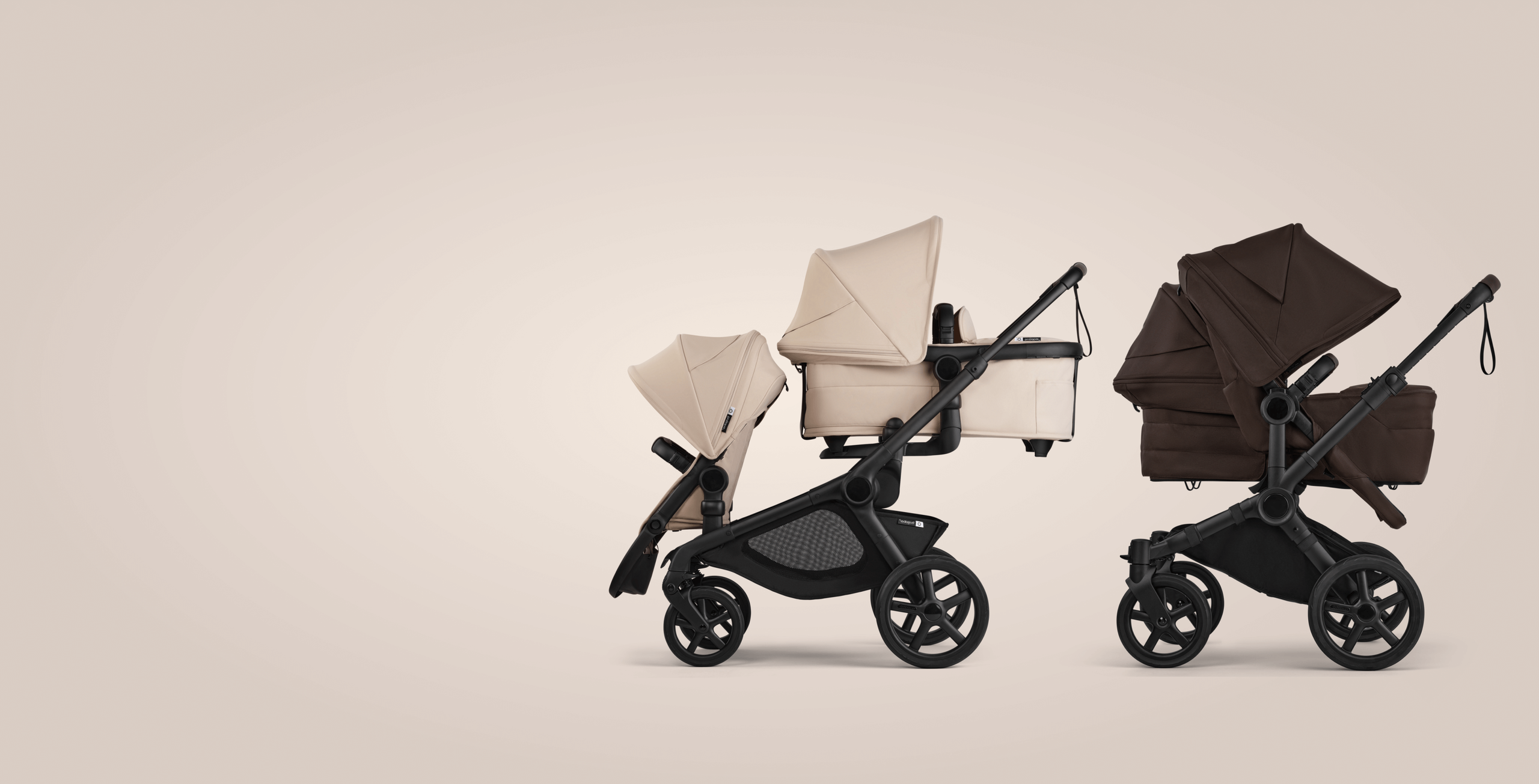 Two Bugaboo prams in a row. On the left, a Bugaboo Kangaroo tandem pram with a seat and a pram body, in Desert Taupe fabrics. On the right, a Bugaboo Donkey 6 double pram with a seat and a pram body, in Cocoa Brown fabrics.