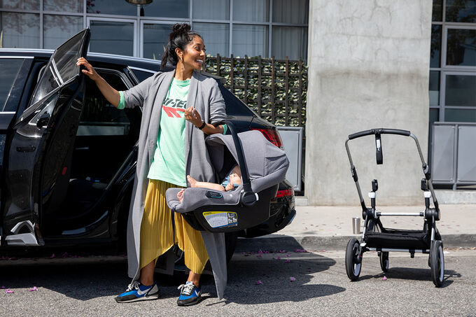 Mom holing car seat next to stroller