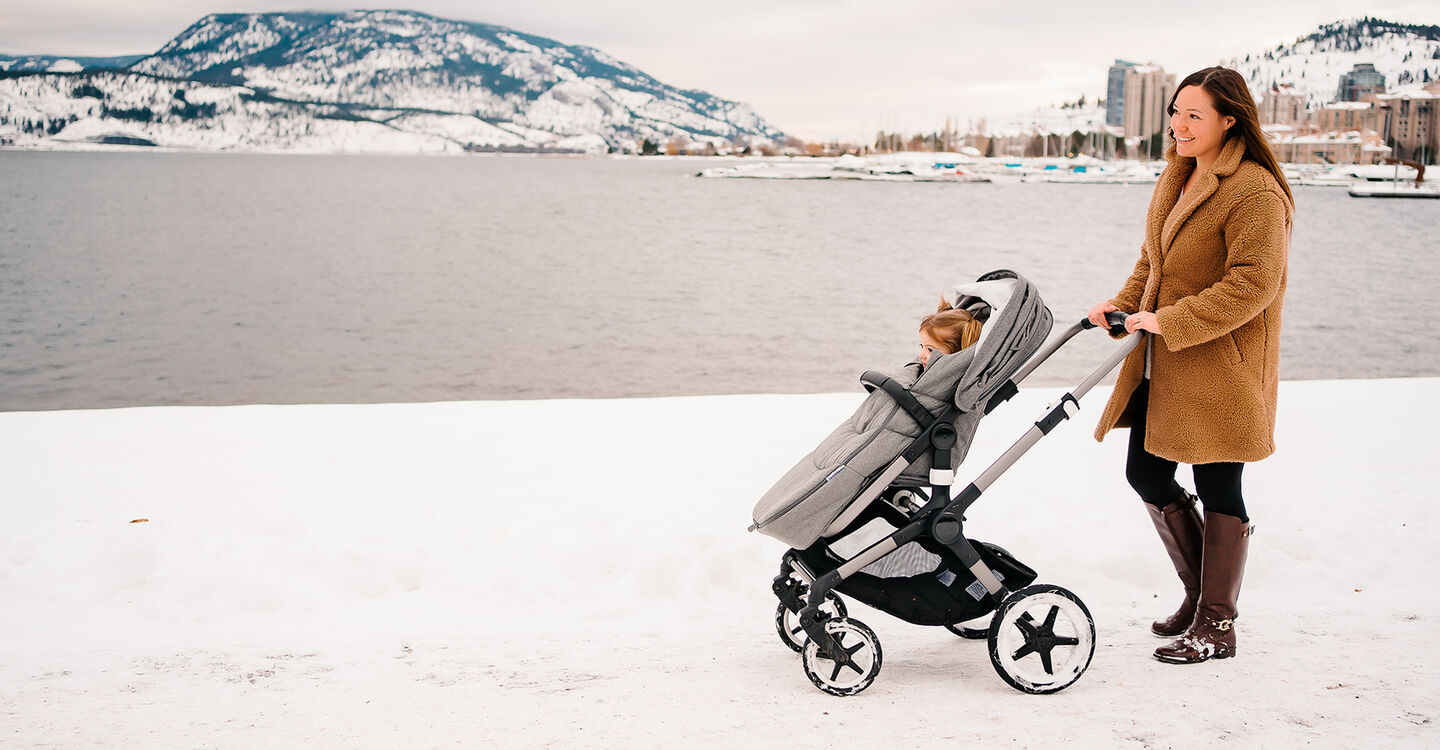 Mom with baby in stroller in snow