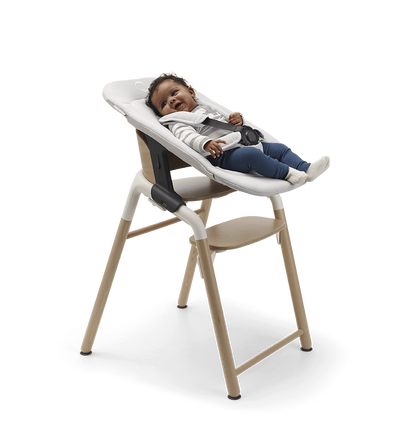 Baby in einem Bugaboo Giraffe Stuhl mit Neugeborenen-Set.
