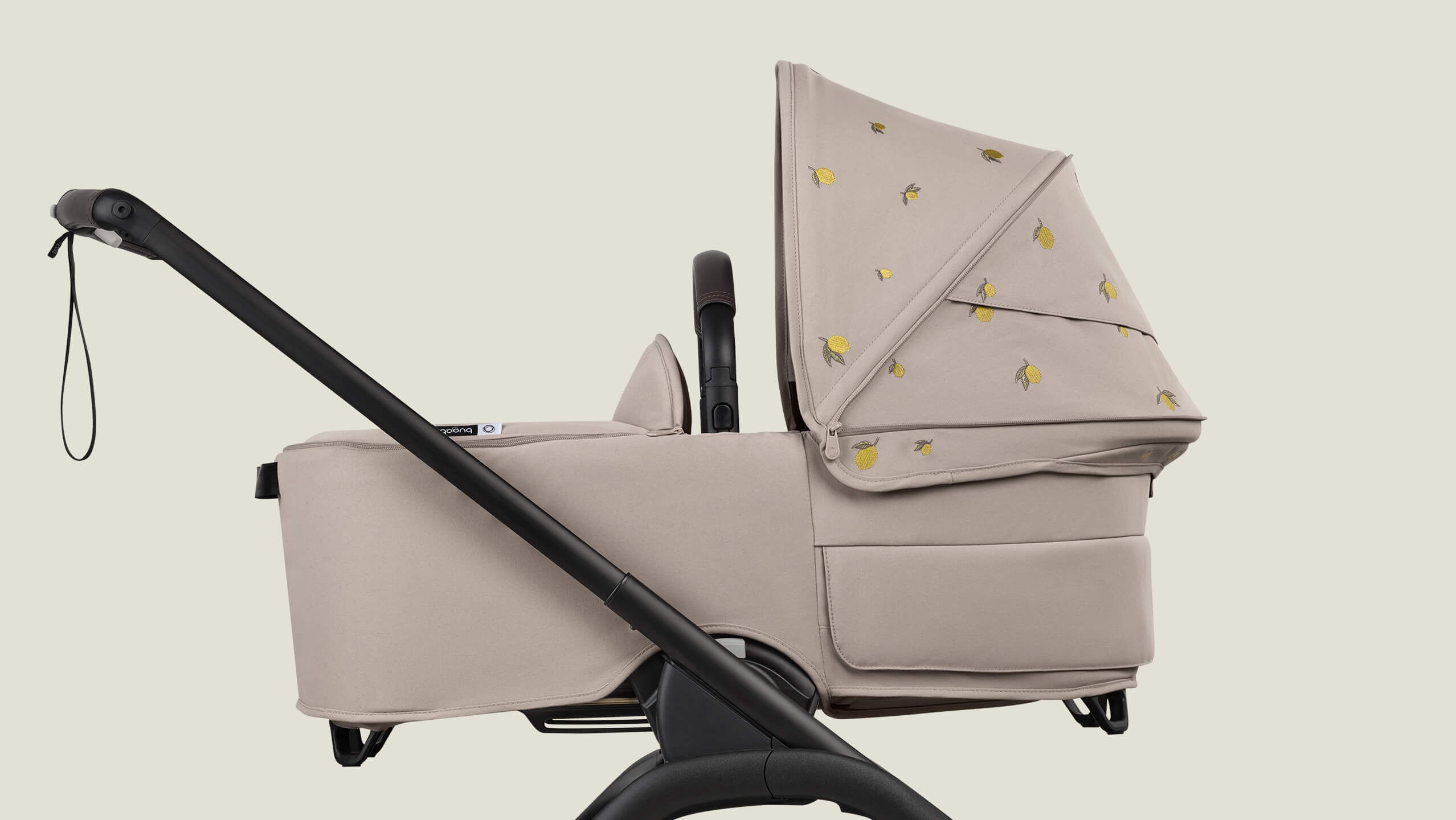 A Bugaboo Dragonfly bassinet stroller with Bugaboo X Konges Sløjd Limited Edition sun canopy, featuring Konges Sløjd's signature lemon print.
