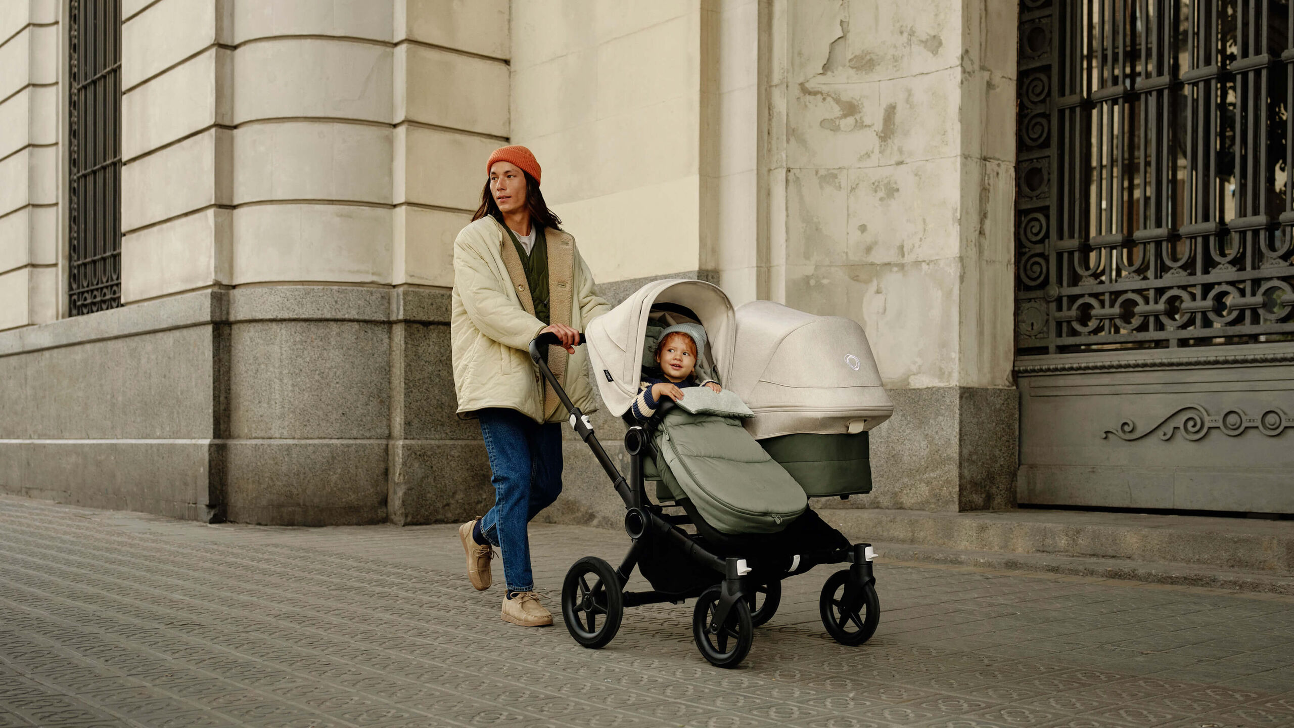 A father strolls with a children in a Bugaboo Donkey 5 double pram.