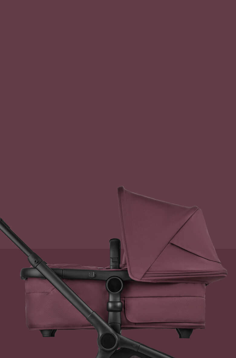 A Bugaboo Fox 5 Renew bassinet pushchair in Dark Cherry colorway, placed on a magenta background.