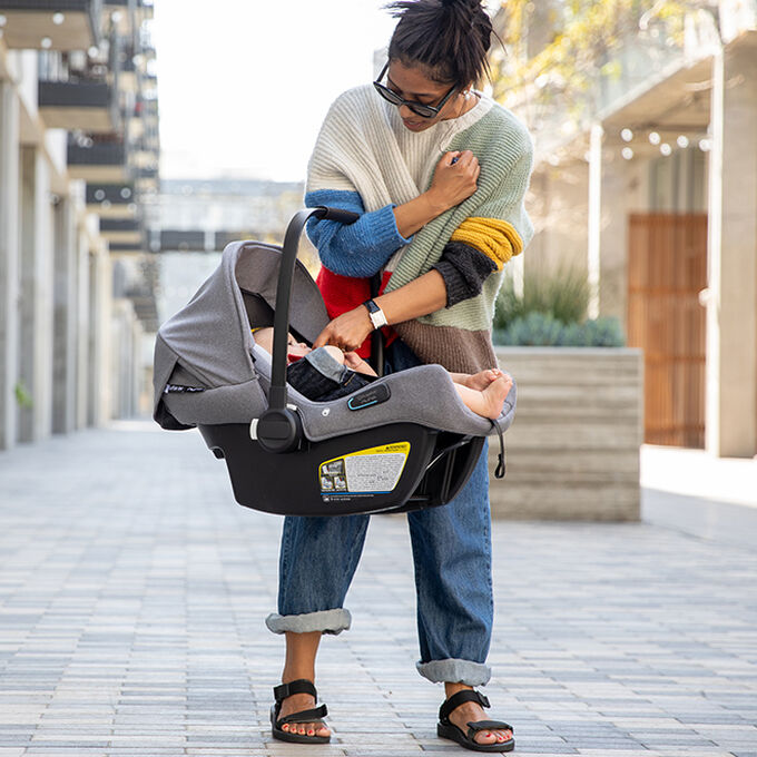 Woman carrying Turtle Air by Nuna car seat