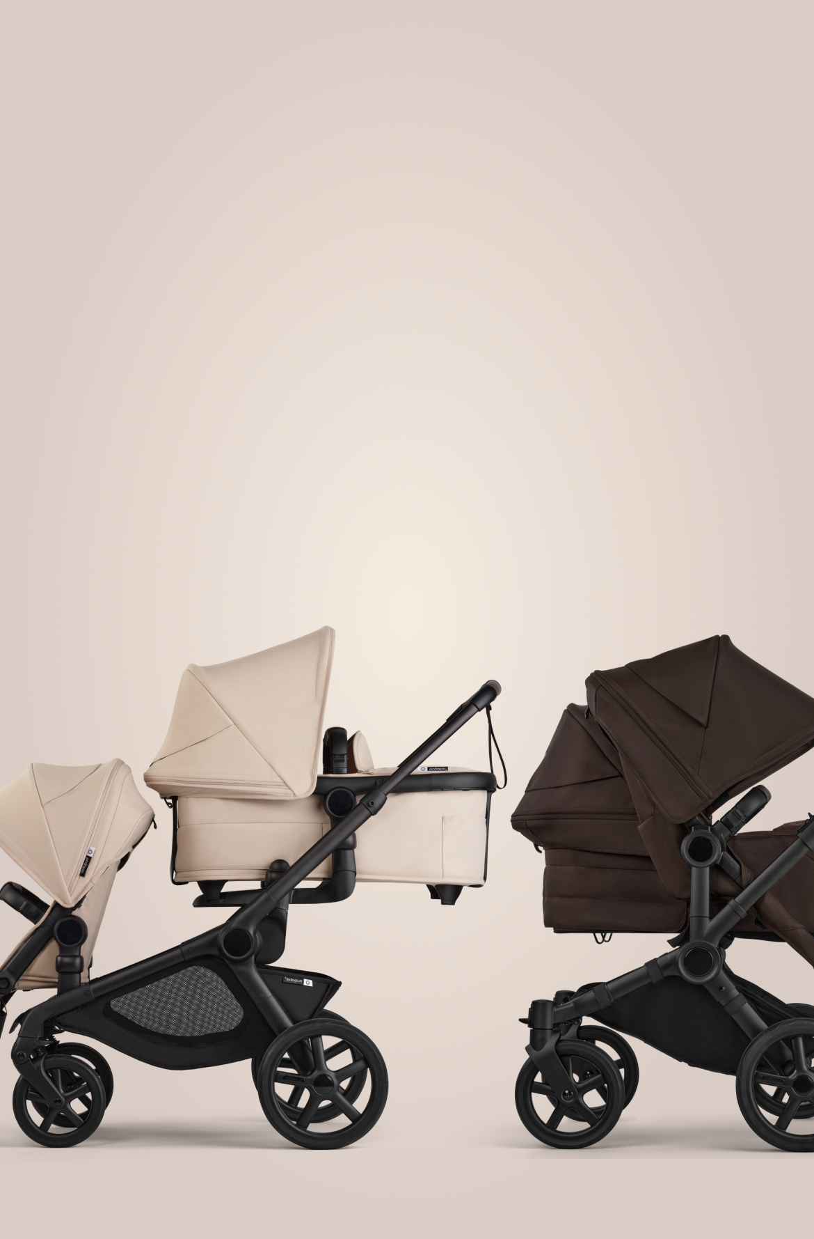 Two Bugaboo prams in a row. On the left, a Bugaboo Kangaroo tandem pram with a seat and a pram body, in Desert Taupe fabrics. On the right, a Bugaboo Donkey 6 double pram with a seat and a pram body, in Cocoa Brown fabrics.