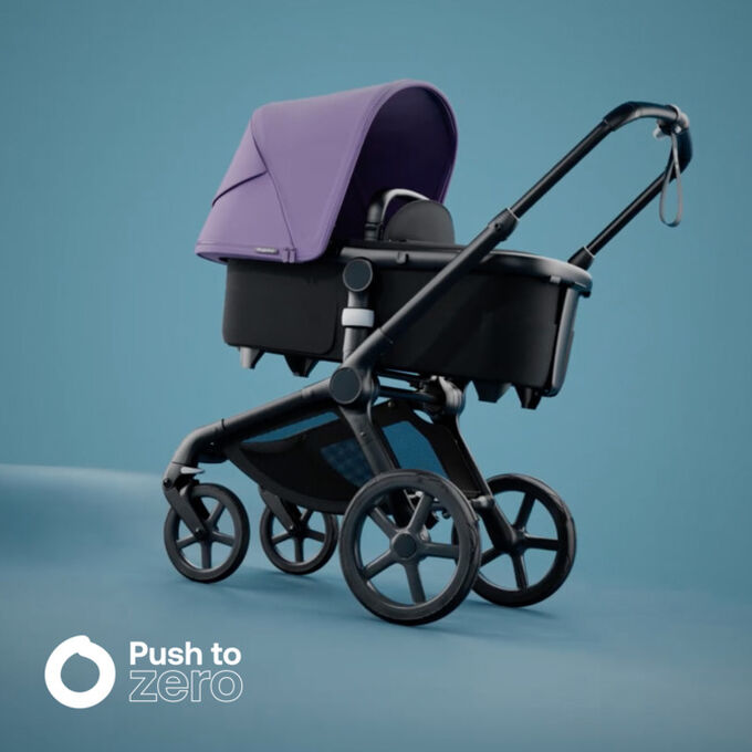 Bugaboo Fox 5 bassinet stroller with Astro purple sun canopy; in the corner is Bugaboo's Push to zero logo.