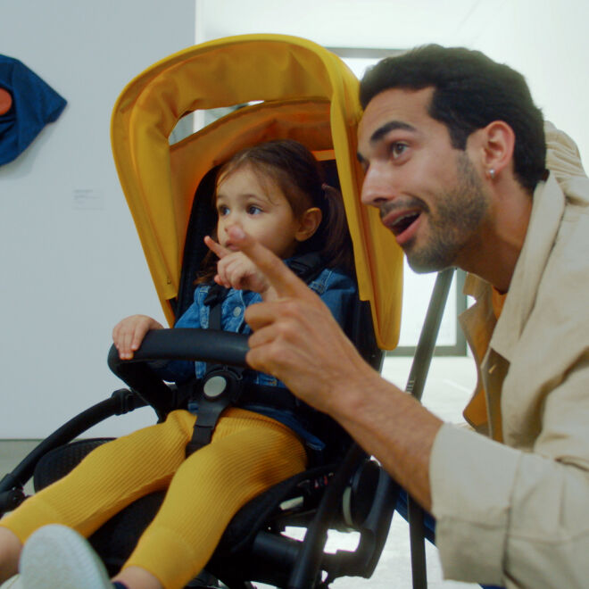 Dad excitedly pointing at something offscreen to toddler in a Bee 6 stroller.